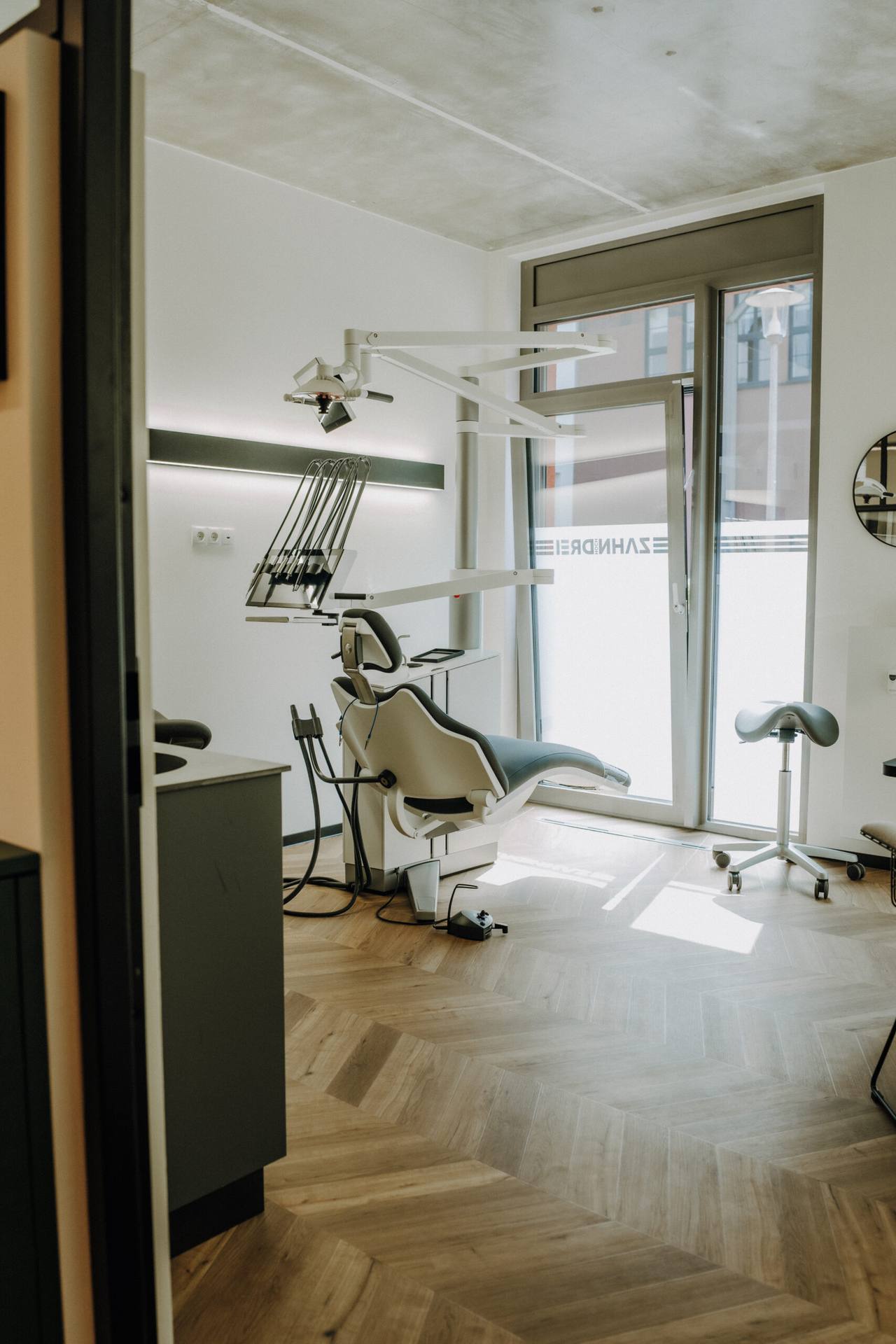 Ruhiges, sonnendurchflutetes Behandlungszimmer durch die offene Tür gesehen