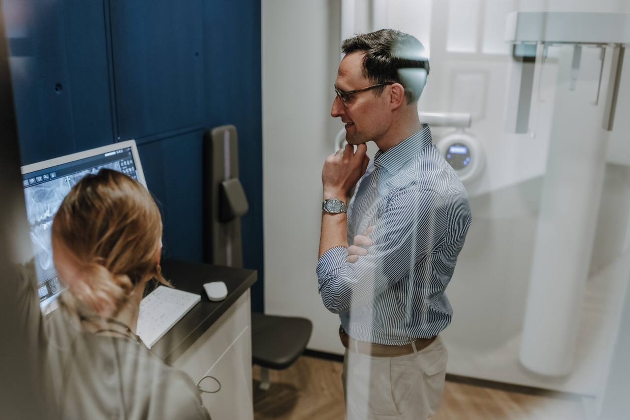 Mitarbeiterin positioniert einen Patienten am digitalen DVT-Röntgengerät