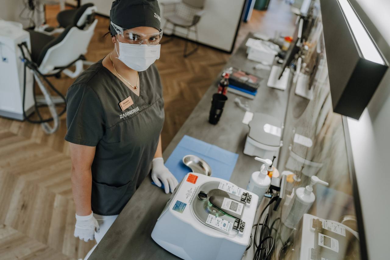 Mitarbeiterin mit Schutzbrille bei der Aufbereitung der Instrumente am Hygienetresen
