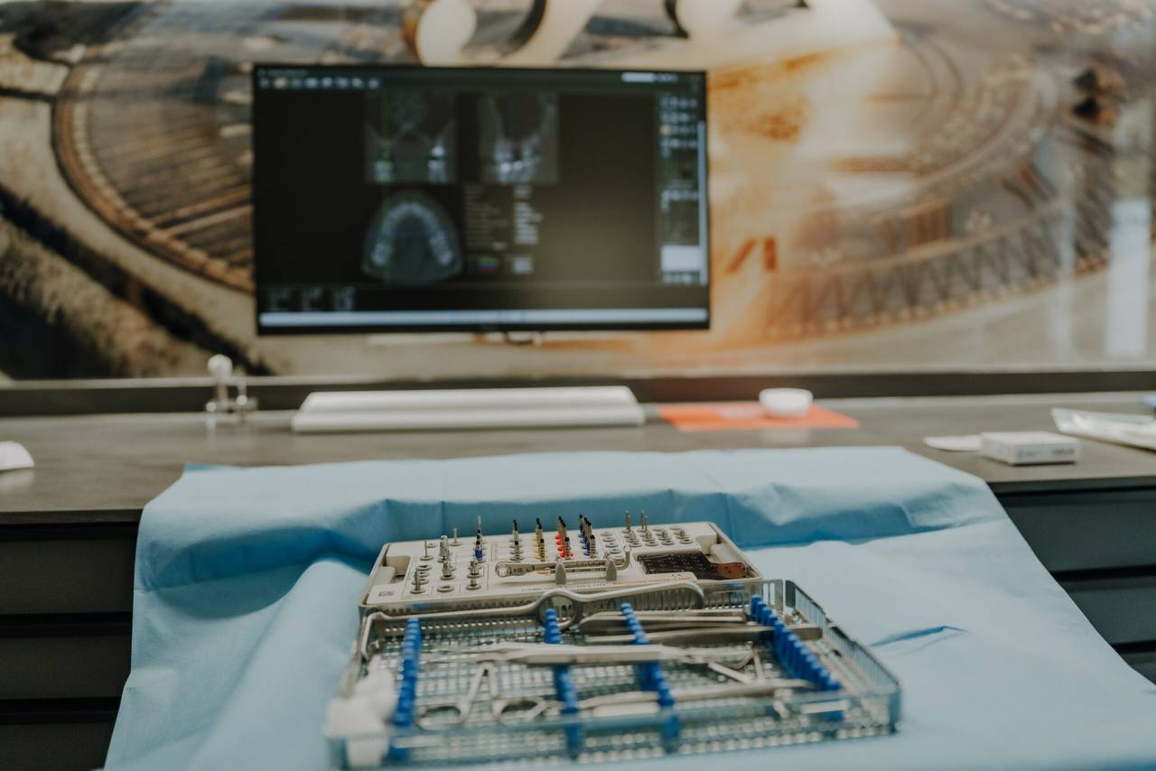Implantologisches Instrumentarium vor dem Monitor mit der digitalen 3D-Implantatplanung
