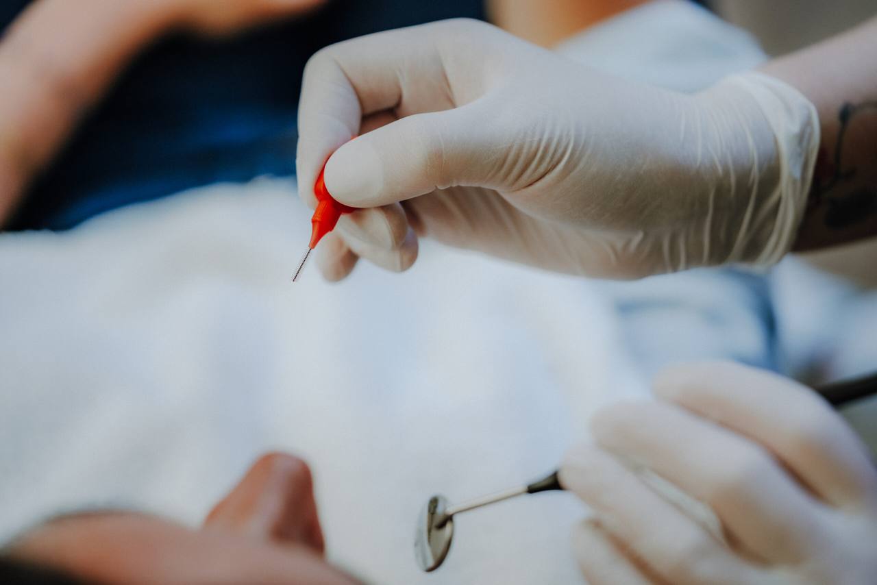 Interdentalbürste in Nahaufnahme — Demonstration der Pflege der Zahnzwischenräume
