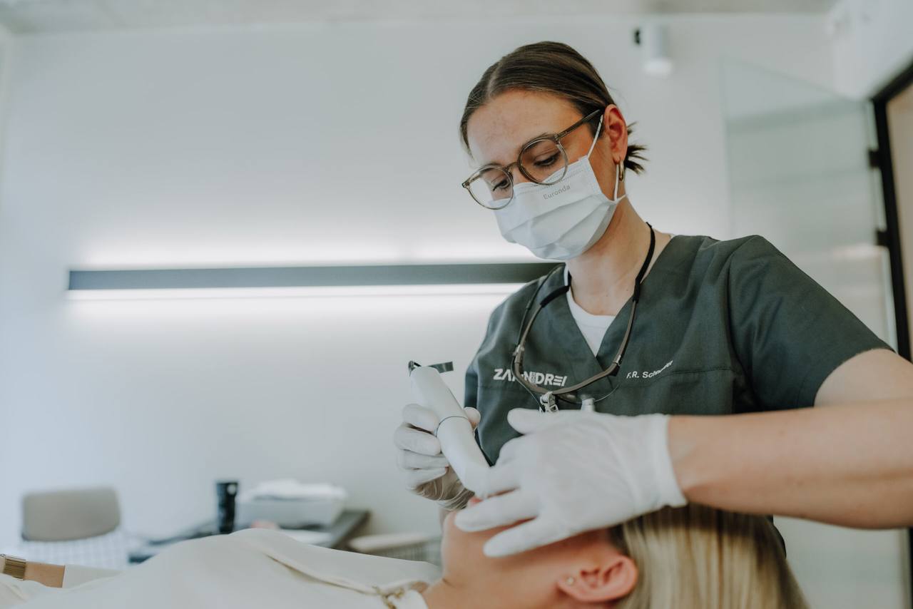 Franziska-Roberta Schneider führt mit dem Intraoralscanner einen 3D-Scan bei einer Patientin durch