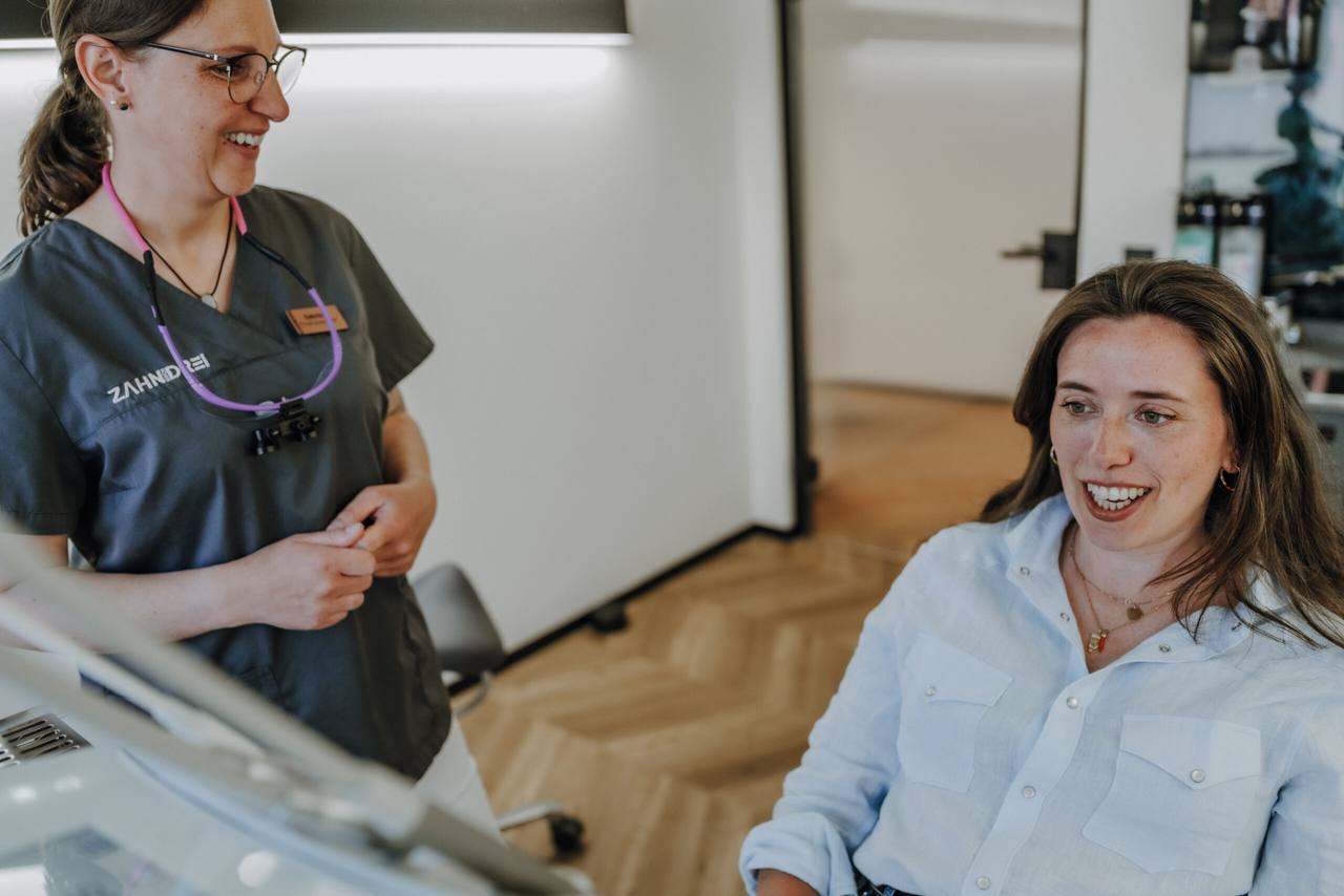 Prophylaxe-Expertin im lockeren Gespräch mit einer lachenden Patientin